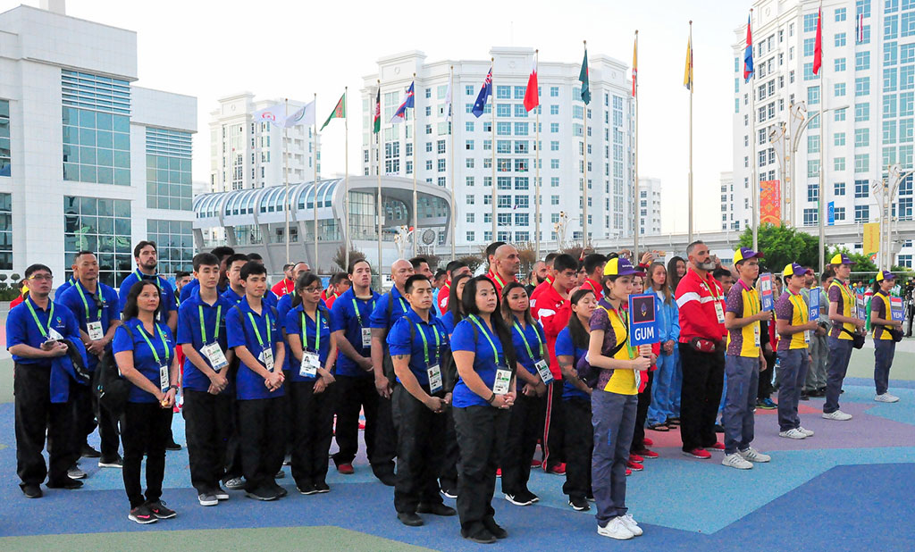 The flags of five countries participating in the Games are hoisted in the Olympic village
