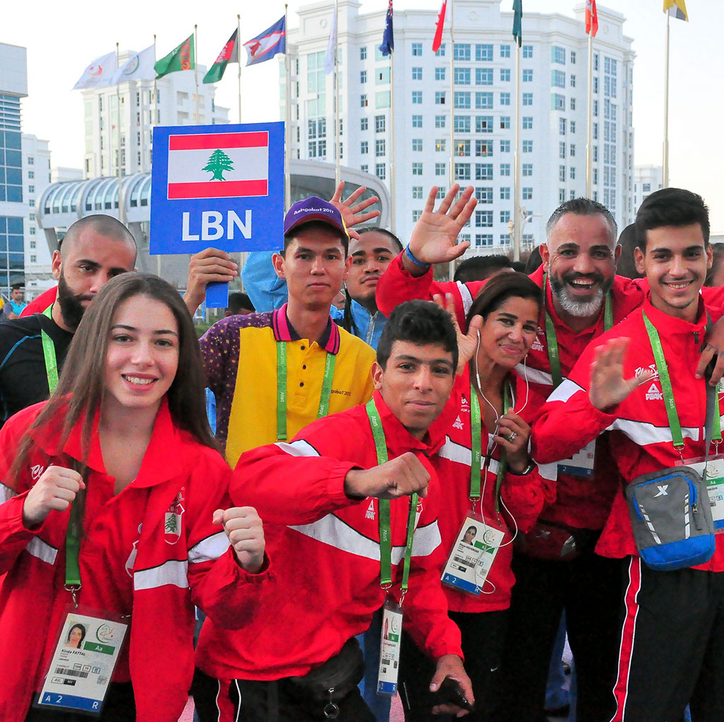 The flags of five countries participating in the Games are hoisted in the Olympic village